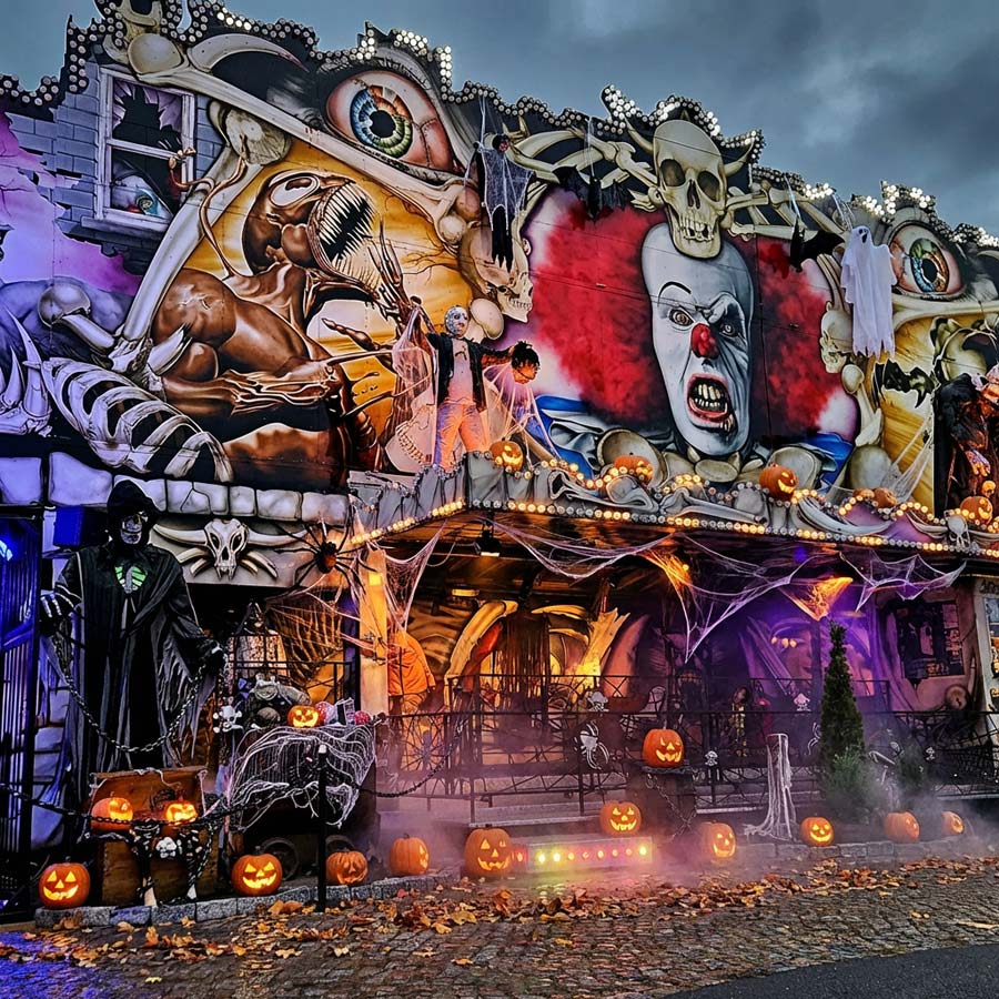 Der Eingang zu einer Geisterbahn die mit gruseligen Kürbissen geschmückt ist.